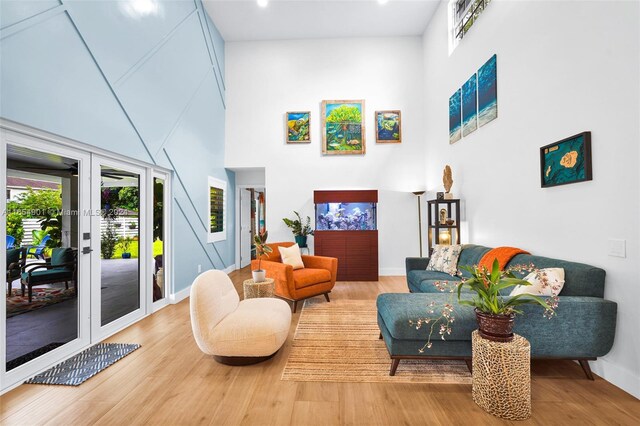 living room featuring a high ceiling, hardwood / wood-style floors, and french doors