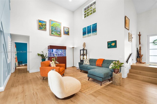 living room with a high ceiling and light hardwood / wood-style floors