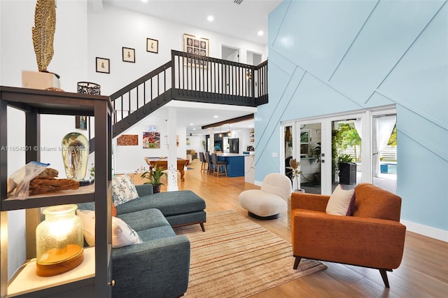 living room with french doors, hardwood / wood-style flooring, and a high ceiling