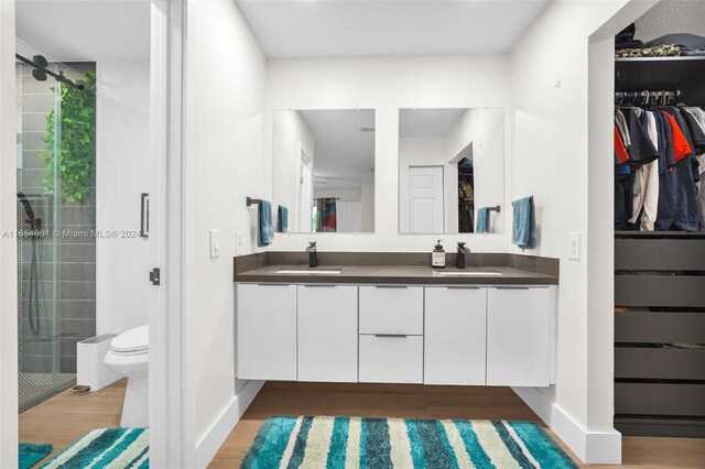 bathroom with vanity, toilet, wood-type flooring, and walk in shower