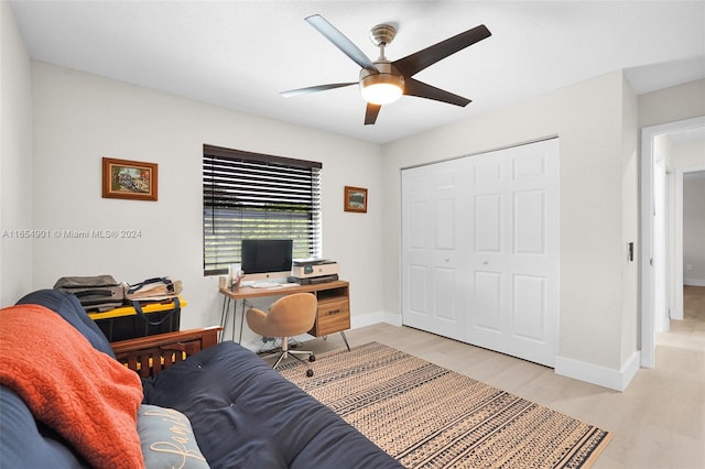 home office with ceiling fan and light hardwood / wood-style flooring