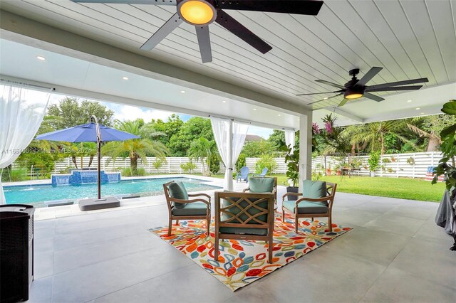 view of patio / terrace with pool water feature, ceiling fan, and a fenced in pool