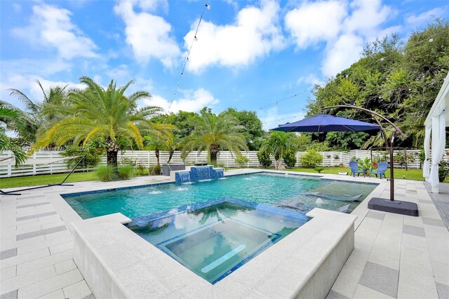 view of swimming pool with pool water feature, a patio area, and an in ground hot tub