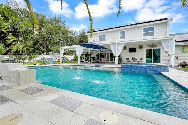 view of pool with pool water feature and a patio