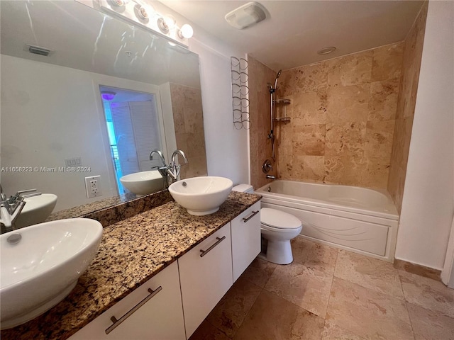 full bathroom with tiled shower / bath, toilet, and vanity