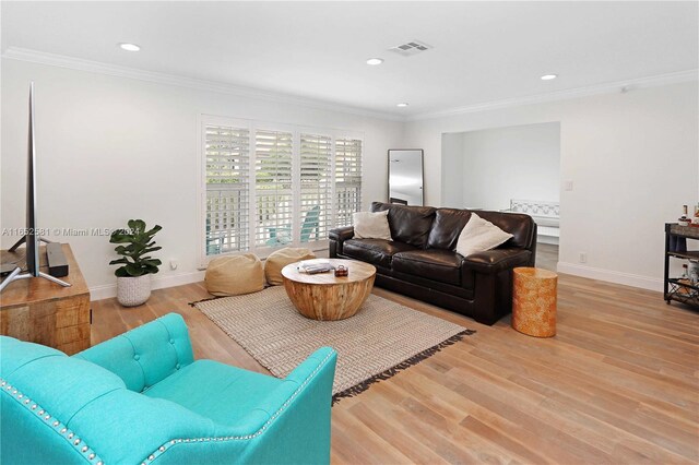 living room with crown molding and light wood-type flooring