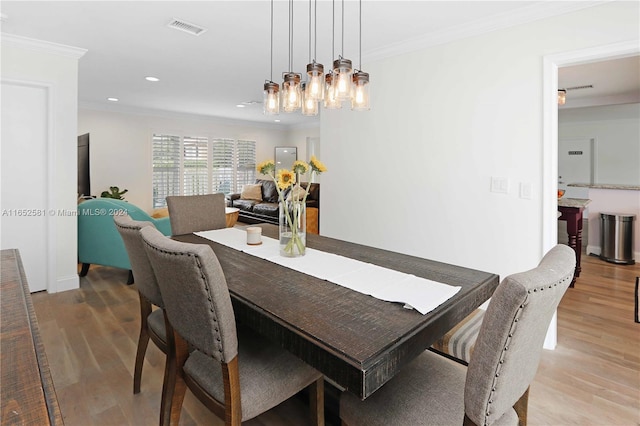 dining room featuring ornamental molding, an inviting chandelier, and hardwood / wood-style floors