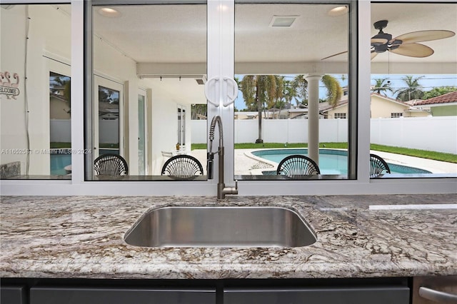 kitchen with ceiling fan, a textured ceiling, and sink