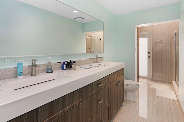 bathroom featuring a tile shower, toilet, and vanity