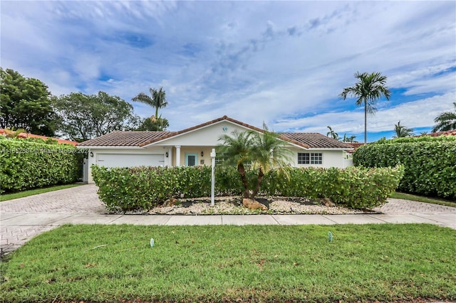 view of front of home with a garage and a front lawn