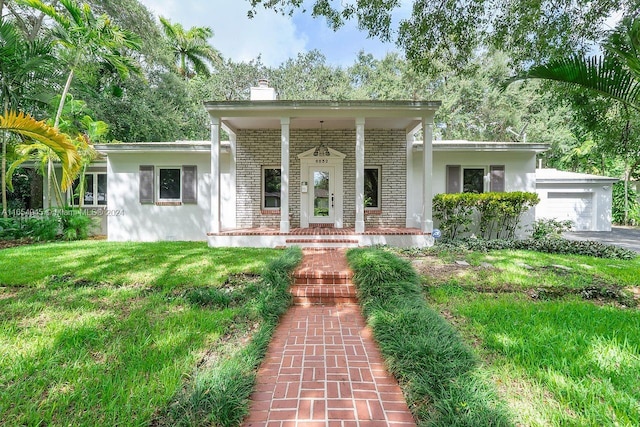 view of front of property with a front lawn, a garage, and a porch