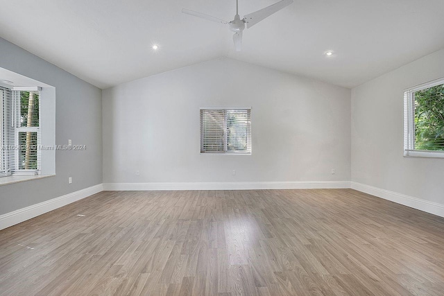 empty room with vaulted ceiling, ceiling fan, and light hardwood / wood-style floors