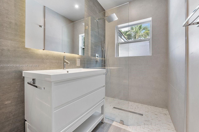 bathroom with vanity, tile walls, and a tile shower