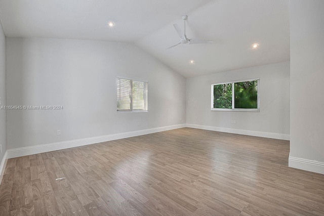 spare room with ceiling fan, light wood-type flooring, and vaulted ceiling