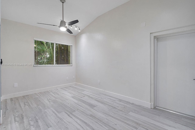 empty room featuring light hardwood / wood-style flooring, ceiling fan, and vaulted ceiling