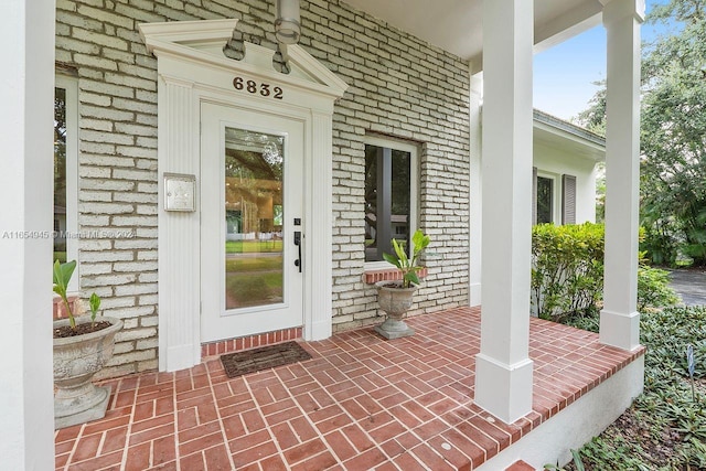 view of exterior entry featuring covered porch