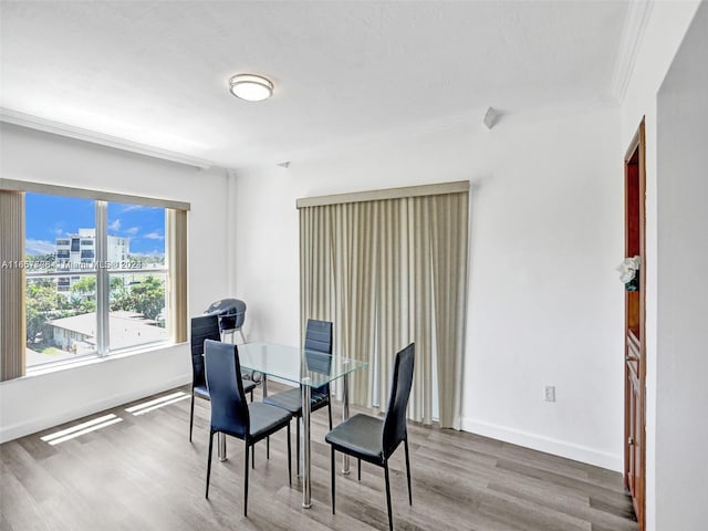 dining room with crown molding and hardwood / wood-style flooring