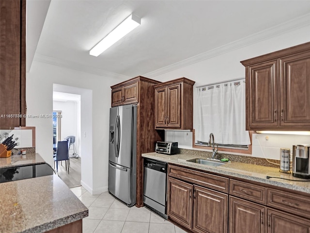 kitchen with light tile patterned floors, crown molding, light stone counters, stainless steel appliances, and sink