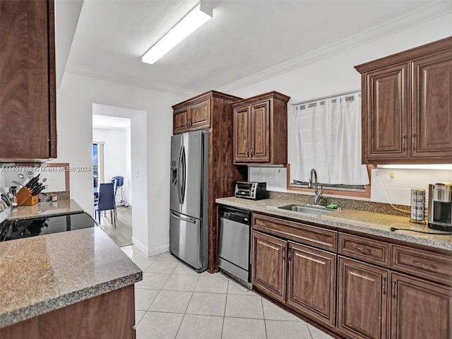 kitchen featuring light stone countertops, appliances with stainless steel finishes, ornamental molding, sink, and light tile patterned flooring