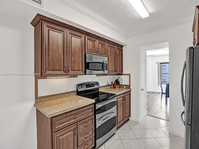 kitchen featuring crown molding, light hardwood / wood-style flooring, backsplash, stainless steel appliances, and light stone counters