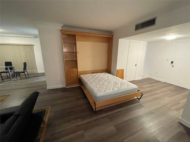 bedroom with dark hardwood / wood-style flooring