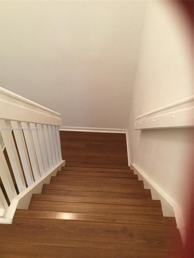 stairs featuring hardwood / wood-style floors