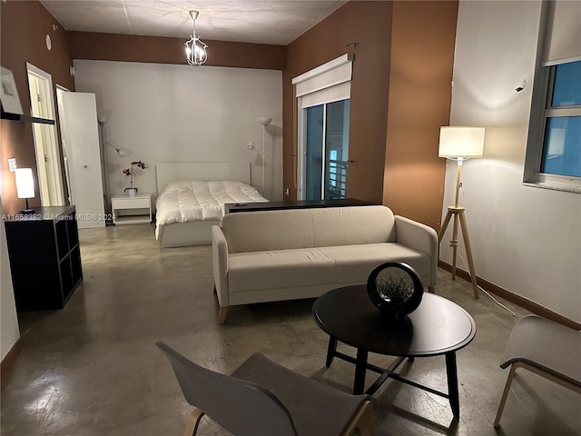 bedroom with a notable chandelier and concrete flooring