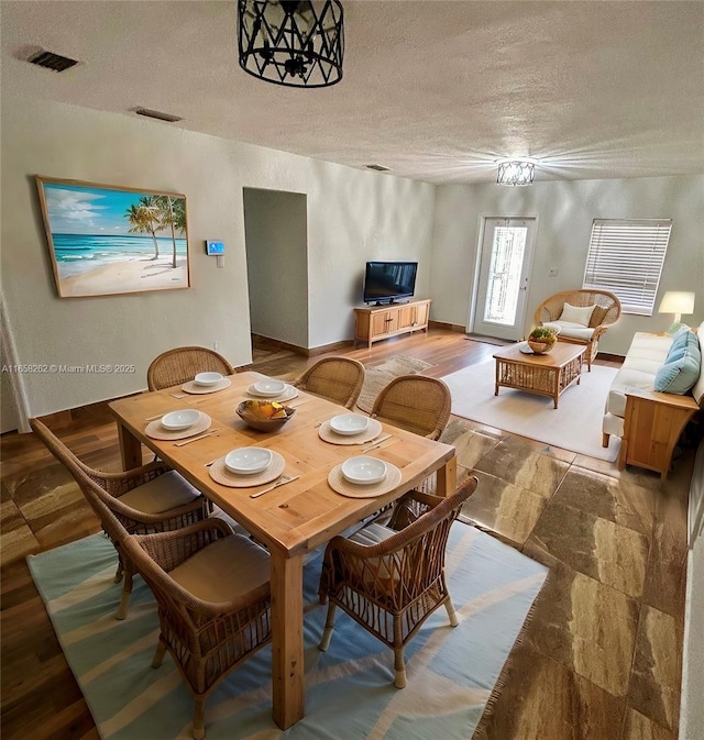 dining room featuring a textured ceiling and an inviting chandelier