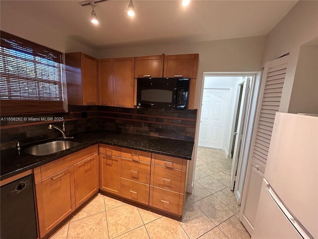 kitchen featuring light tile patterned flooring, sink, dark stone countertops, and black appliances