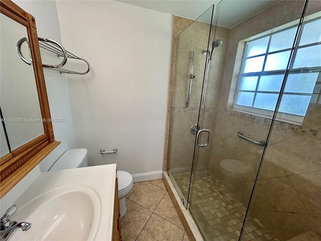 bathroom with tile patterned floors, toilet, vanity, and walk in shower