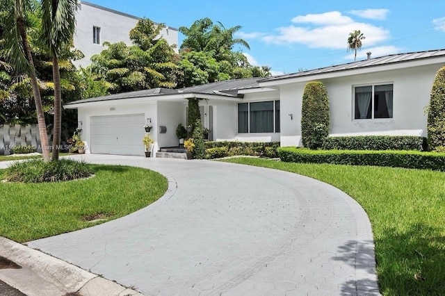 single story home featuring concrete driveway, a front lawn, and stucco siding