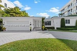 3551 E Glencoe St, Miami, FL 33133 - ranch-style home with decorative driveway, a garage, and stucco siding
