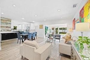 living room featuring recessed lighting, light wood-type flooring, and visible vents