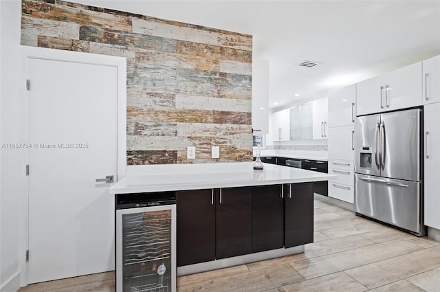 kitchen featuring visible vents, beverage cooler, stainless steel refrigerator with ice dispenser, white cabinets, and light countertops