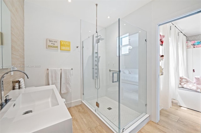 bathroom featuring wood finished floors, a stall shower, and vanity