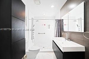 bathroom featuring vanity, toilet, and a shower stall