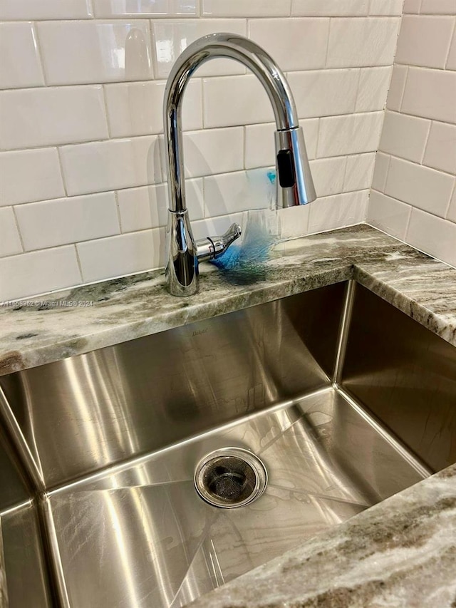 details with light stone countertops, sink, and tasteful backsplash