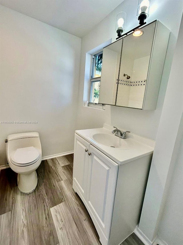 bathroom featuring hardwood / wood-style flooring, vanity, and toilet