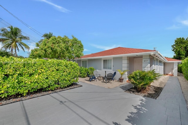 rear view of house with stucco siding and a patio area