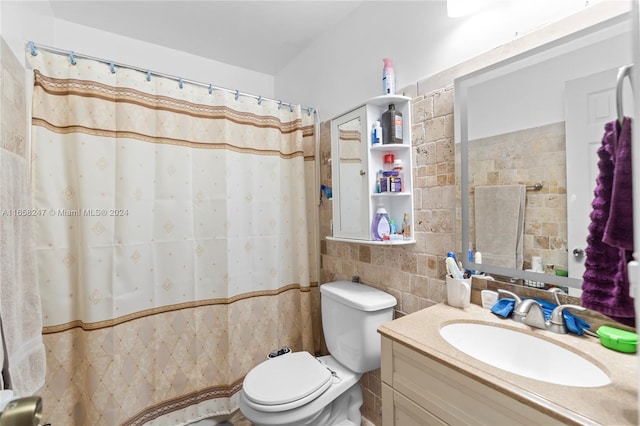 bathroom featuring vanity, toilet, curtained shower, and tile walls