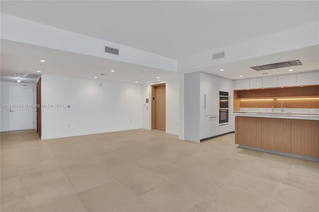 unfurnished living room featuring sink