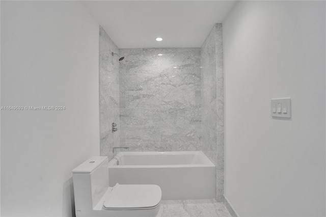 bathroom featuring toilet and tiled shower / bath