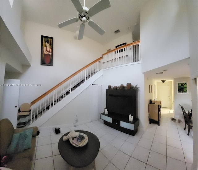 living room with a towering ceiling and ceiling fan