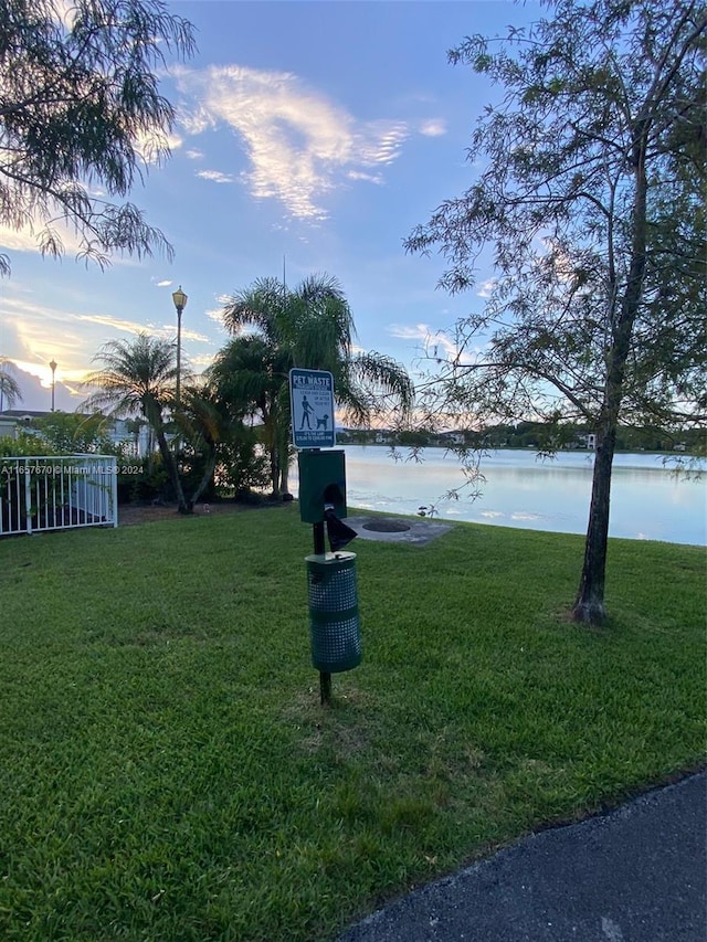 yard at dusk featuring a water view