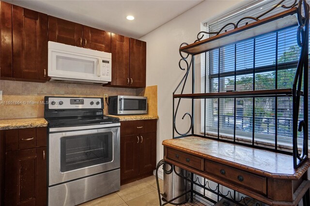 kitchen featuring tasteful backsplash, stainless steel appliances, and light tile patterned flooring