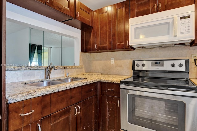 kitchen featuring stainless steel electric range oven, light stone counters, decorative backsplash, and sink