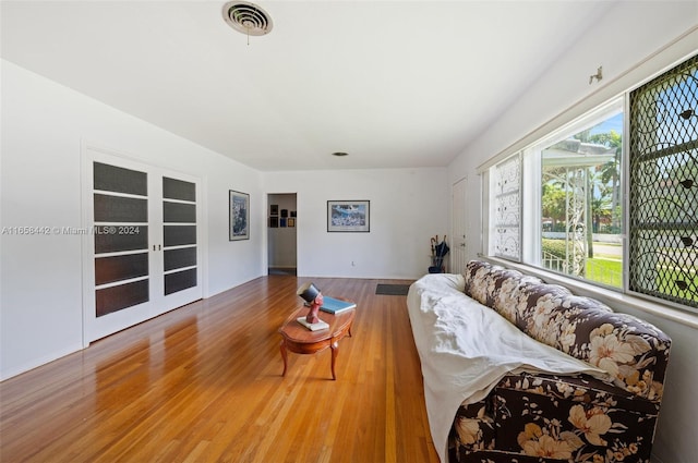 living room featuring french doors, a wealth of natural light, and wood-type flooring