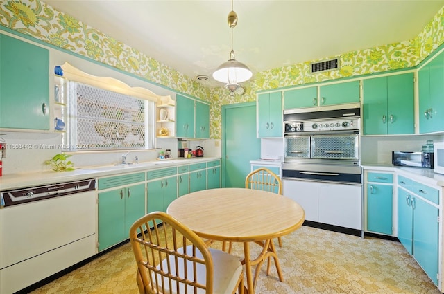 kitchen with green cabinetry, white appliances, pendant lighting, and sink