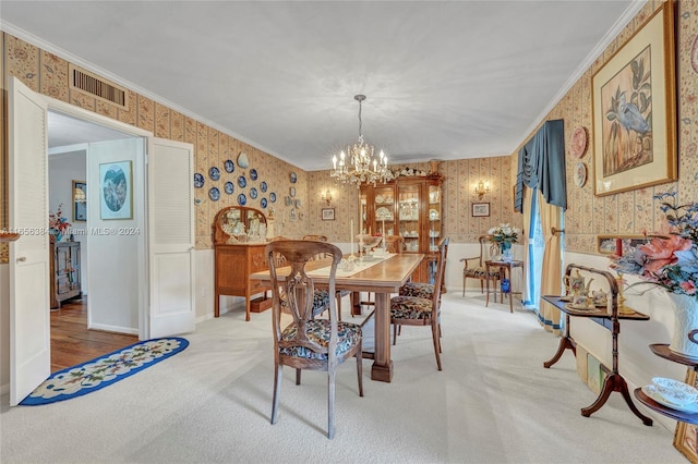 dining space featuring carpet flooring, ornamental molding, and a chandelier