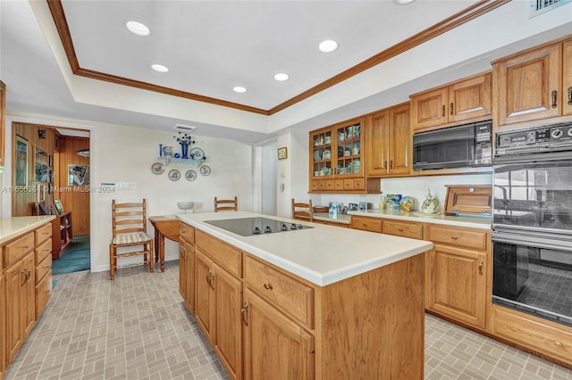 kitchen featuring crown molding, black appliances, tasteful backsplash, and a center island